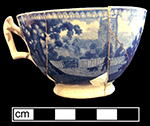 Pearlware handled cup printed underglaze in medium blue with genre scene. Continuous repeating floral interior rim. 4” rim diameter; 2.5” vessel height.
